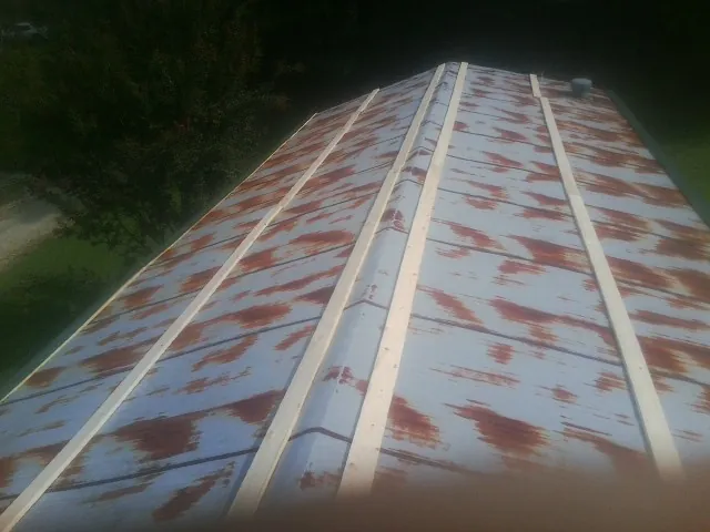 Rusted metal roof panels with new wood purlins before replacement — Storm Damage Roof Repair in Swansboro by Roofing Brothers