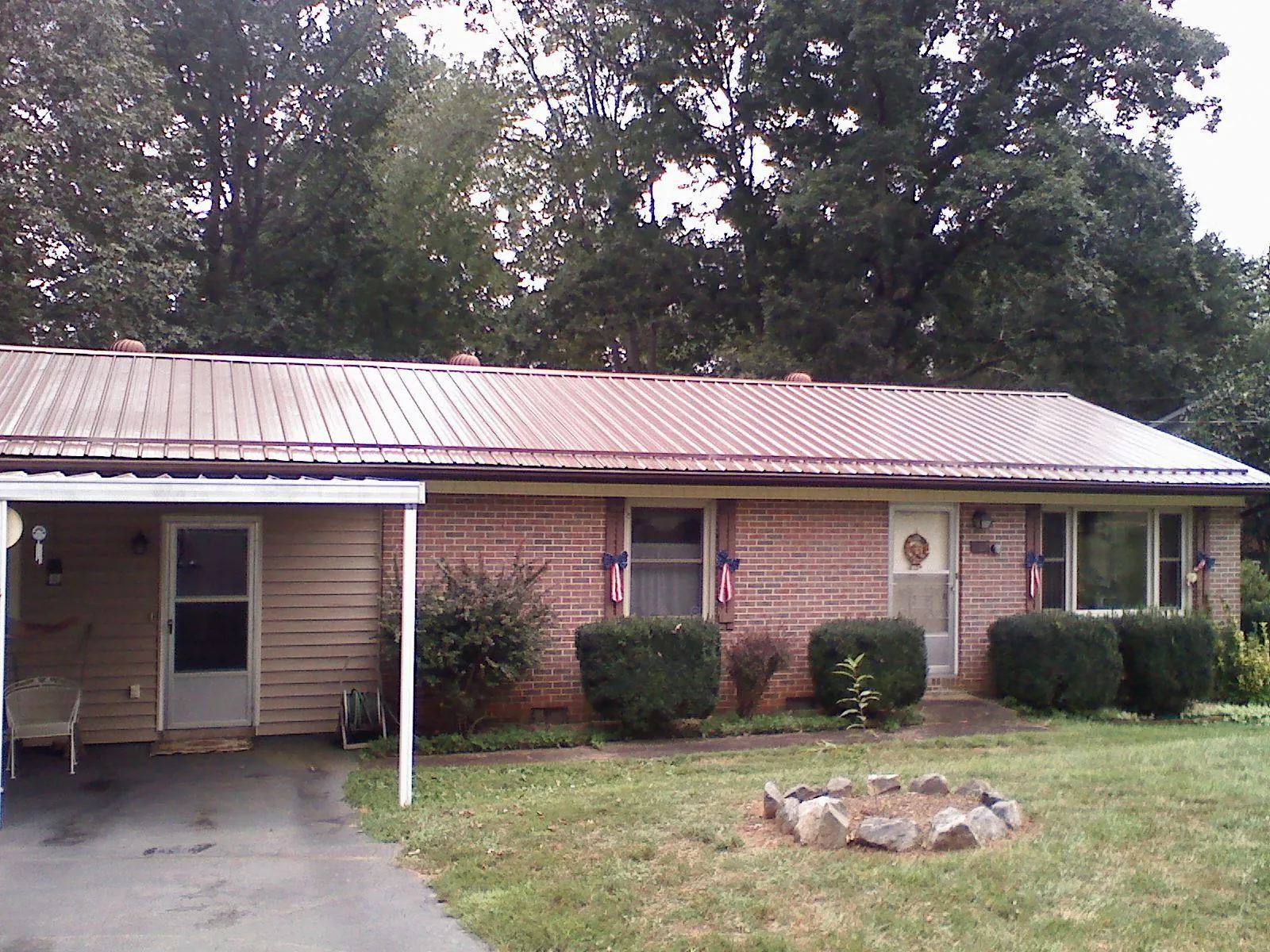 Bronze metal roof and carport on a brick ranch home — Roof Repair work by our crew in Swansboro